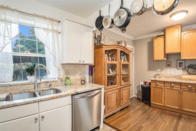 kitchen with crown molding, dishwasher, wood-type flooring, light stone counters, and sink