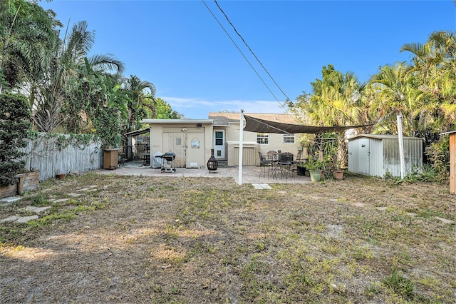 rear view of house with a patio area and a storage shed