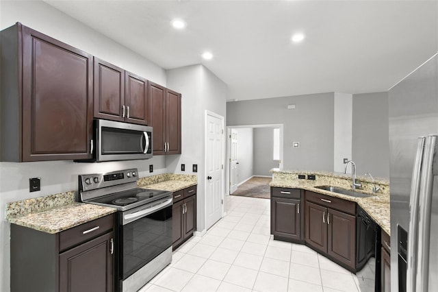 kitchen with dark brown cabinetry, light tile floors, sink, stainless steel appliances, and light stone countertops