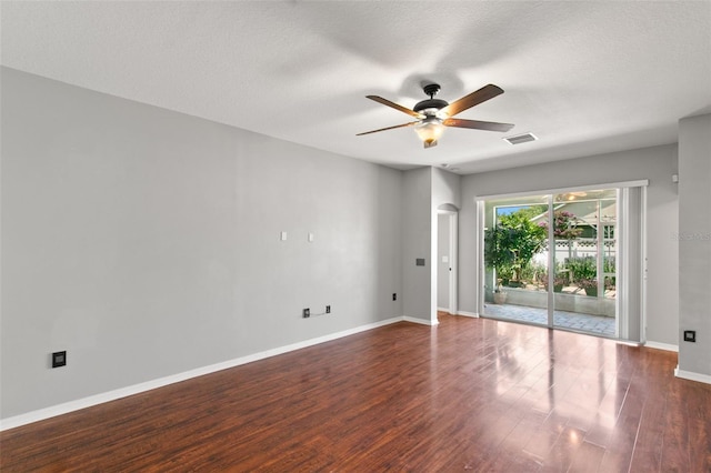 unfurnished room featuring ceiling fan, dark hardwood / wood-style floors, and a textured ceiling