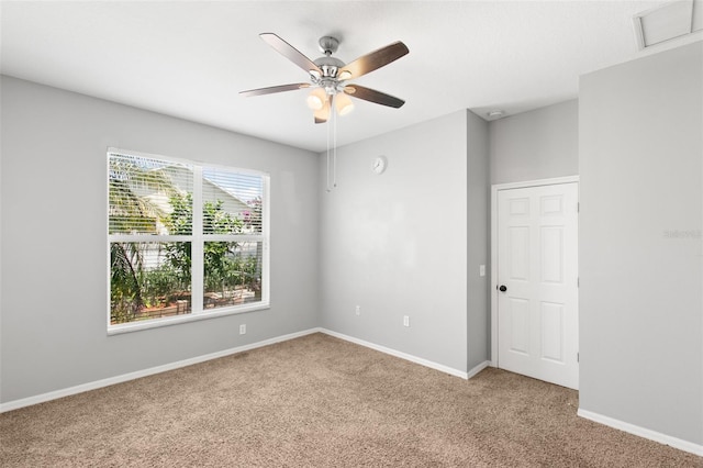 carpeted spare room with ceiling fan