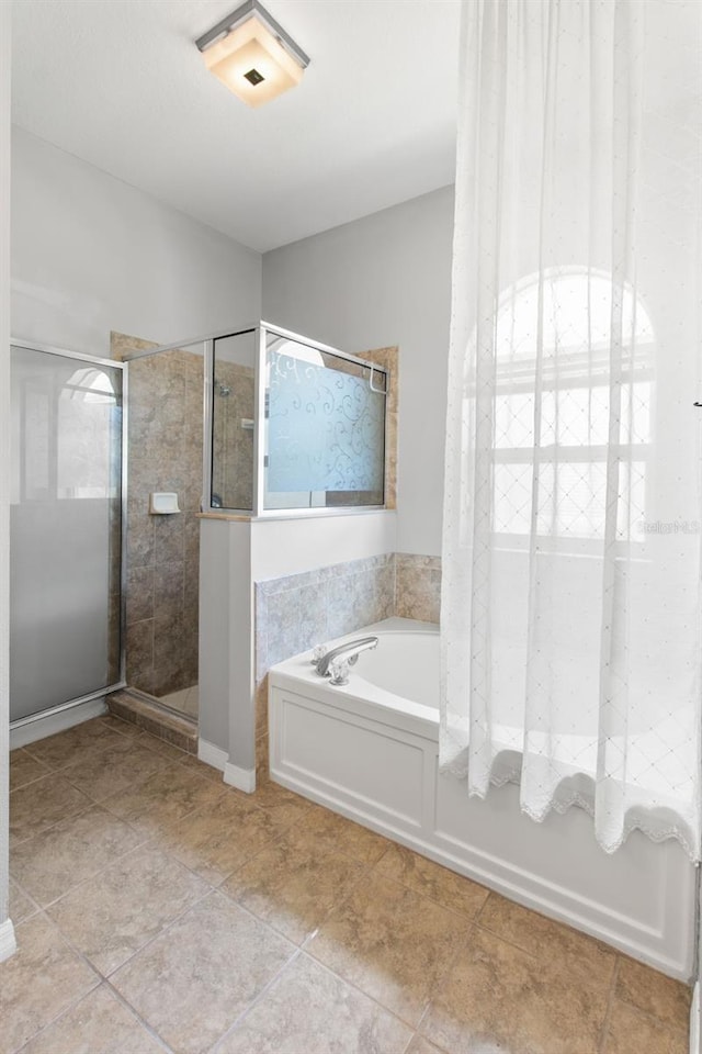 bathroom featuring tile flooring and separate shower and tub