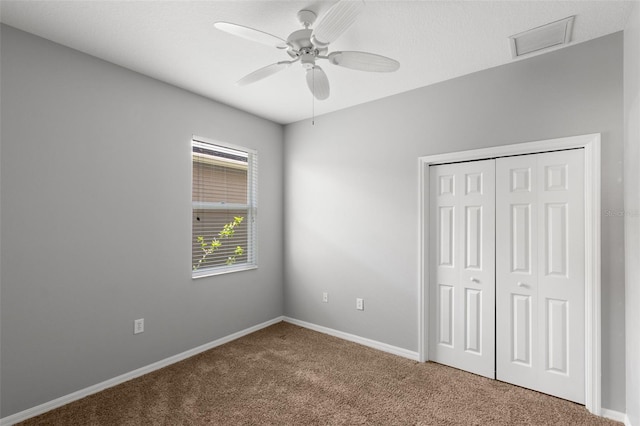 unfurnished bedroom featuring carpet flooring, a closet, and ceiling fan