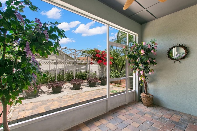 unfurnished sunroom with ceiling fan