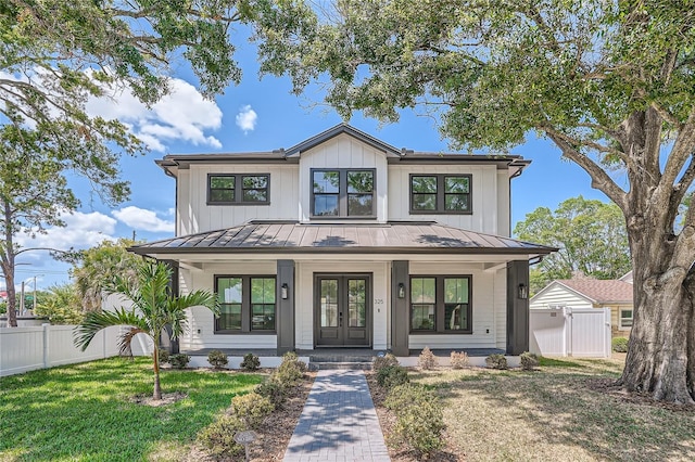 modern inspired farmhouse featuring a front lawn and covered porch