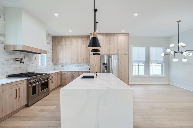 kitchen featuring light hardwood / wood-style flooring, custom exhaust hood, an island with sink, sink, and appliances with stainless steel finishes