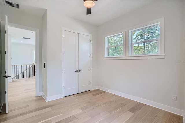 unfurnished bedroom featuring a closet, ceiling fan, and light hardwood / wood-style flooring