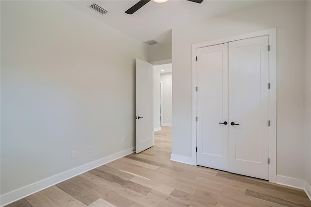 unfurnished bedroom with light hardwood / wood-style floors, a closet, and ceiling fan