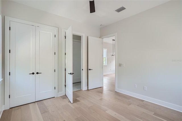 unfurnished bedroom featuring ceiling fan, a closet, and light hardwood / wood-style flooring