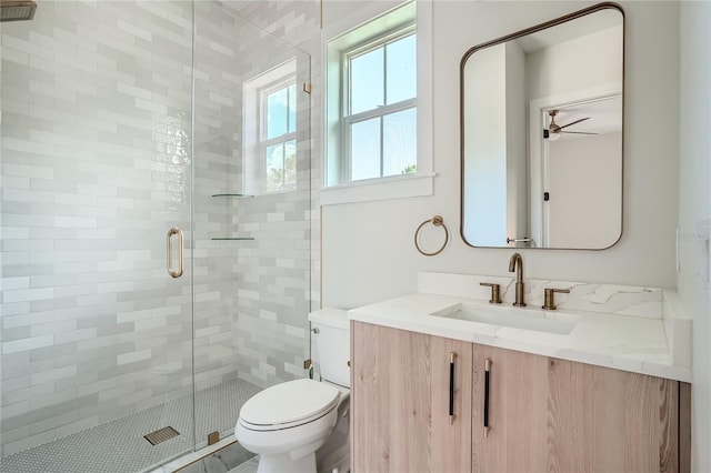 bathroom featuring an enclosed shower, vanity, toilet, and ceiling fan