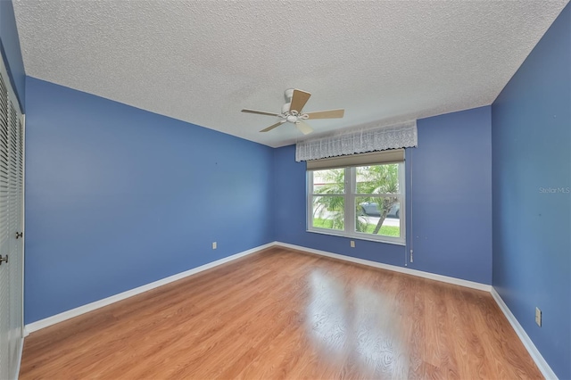 spare room featuring hardwood / wood-style flooring, ceiling fan, and a textured ceiling