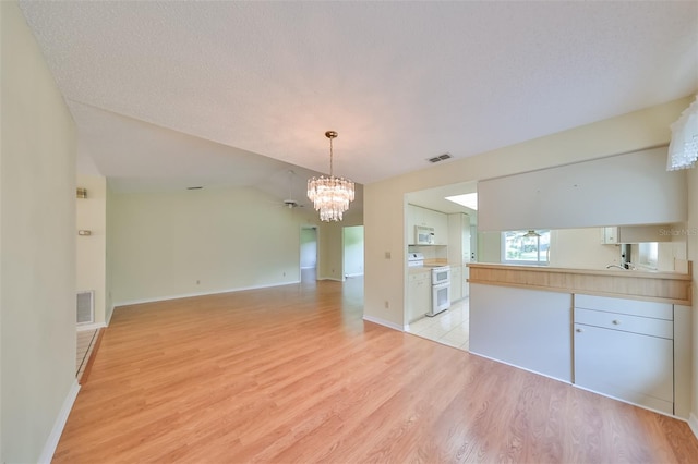 interior space with vaulted ceiling, light hardwood / wood-style floors, and a notable chandelier