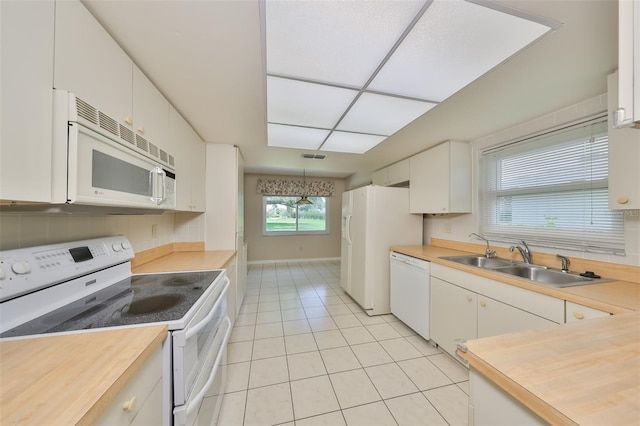 kitchen featuring decorative light fixtures, white appliances, white cabinets, sink, and light tile floors