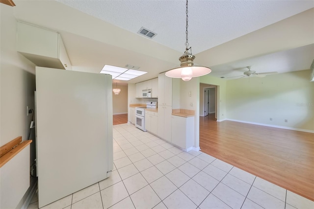 kitchen with pendant lighting, white cabinets, white appliances, light hardwood / wood-style floors, and ceiling fan