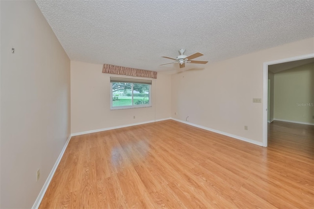 empty room with a textured ceiling, ceiling fan, and light hardwood / wood-style floors