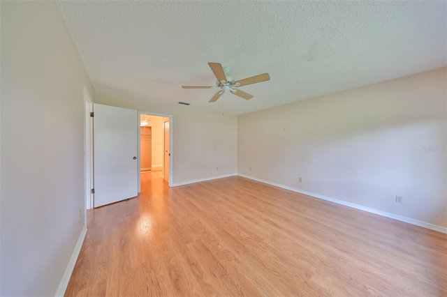 unfurnished room featuring light hardwood / wood-style floors, ceiling fan, and a textured ceiling