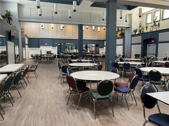 dining room with light wood-type flooring and a high ceiling