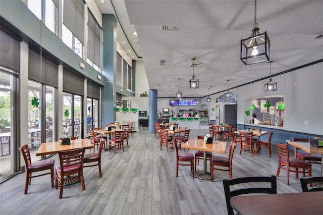 dining room with a high ceiling and light hardwood / wood-style flooring