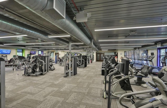 exercise room featuring light carpet