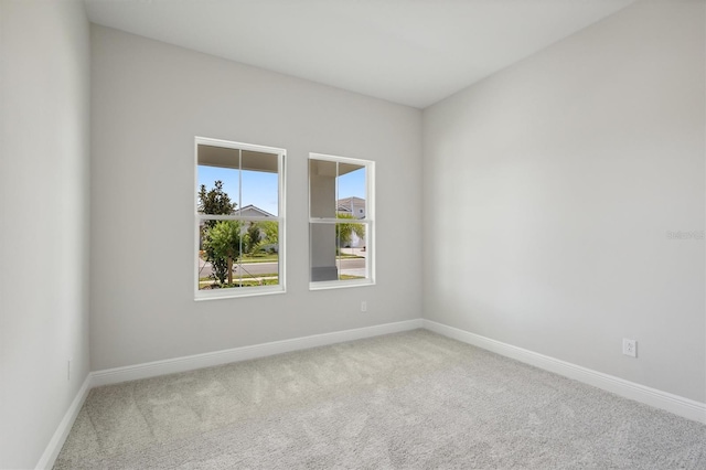 carpeted spare room featuring baseboards