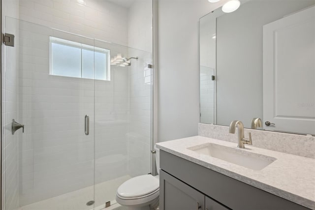 bathroom featuring toilet, walk in shower, and vanity