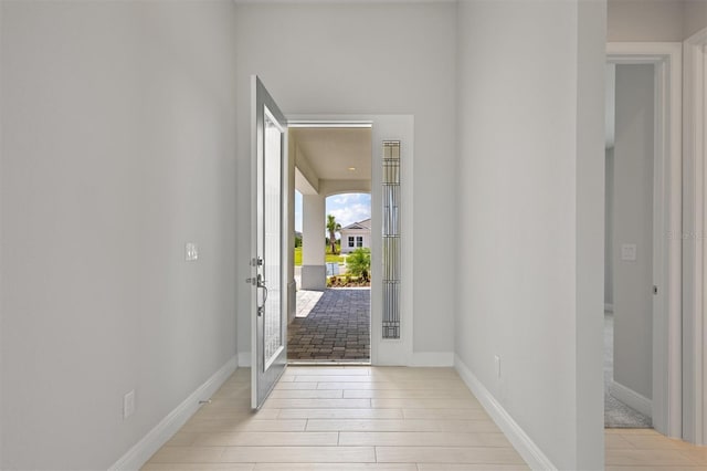 foyer with light wood-type flooring and baseboards