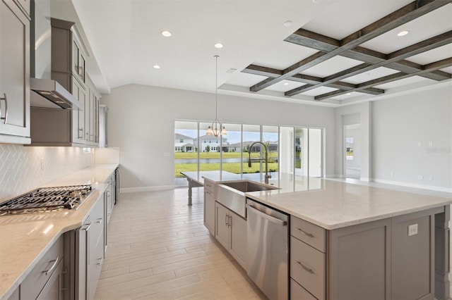 kitchen featuring appliances with stainless steel finishes, beam ceiling, decorative backsplash, coffered ceiling, and a center island with sink