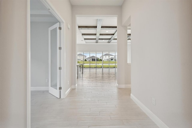 hall featuring light hardwood / wood-style flooring, beamed ceiling, and coffered ceiling