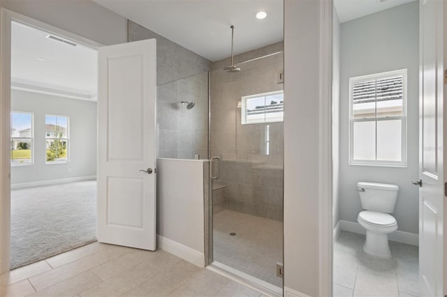 bathroom with tile patterned flooring, toilet, and a shower with shower door