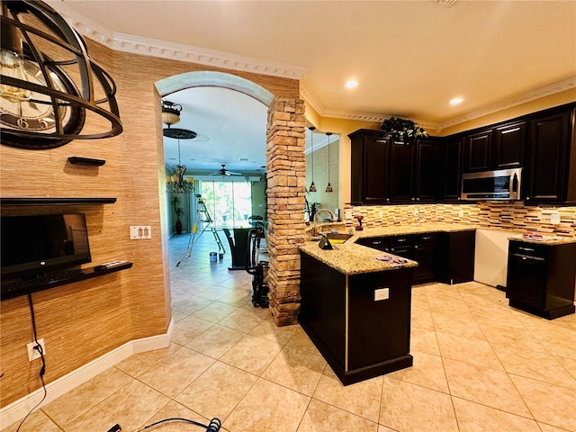 kitchen featuring backsplash, crown molding, light tile floors, and kitchen peninsula