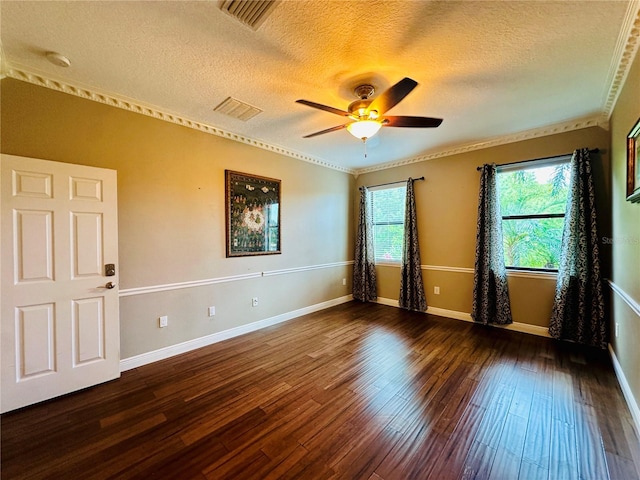 spare room featuring a textured ceiling, ceiling fan, crown molding, and dark wood-type flooring