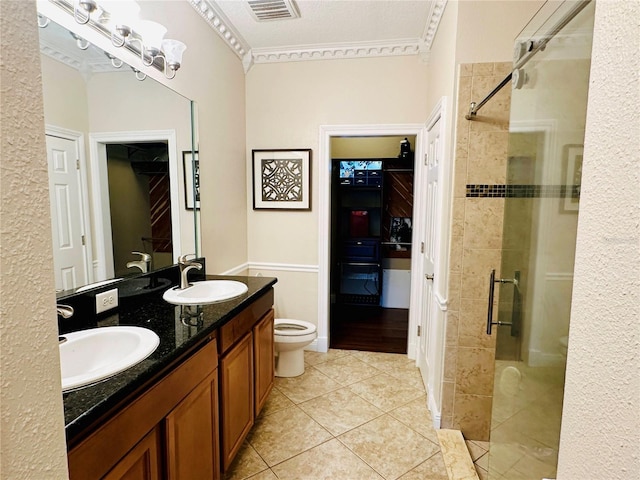 bathroom with dual sinks, ornamental molding, toilet, and walk in shower