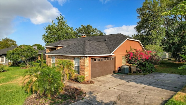 view of front of house with central AC unit, a front yard, and a garage