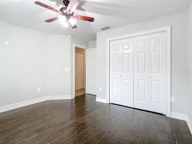 unfurnished bedroom with a textured ceiling, dark hardwood / wood-style flooring, a closet, and ceiling fan