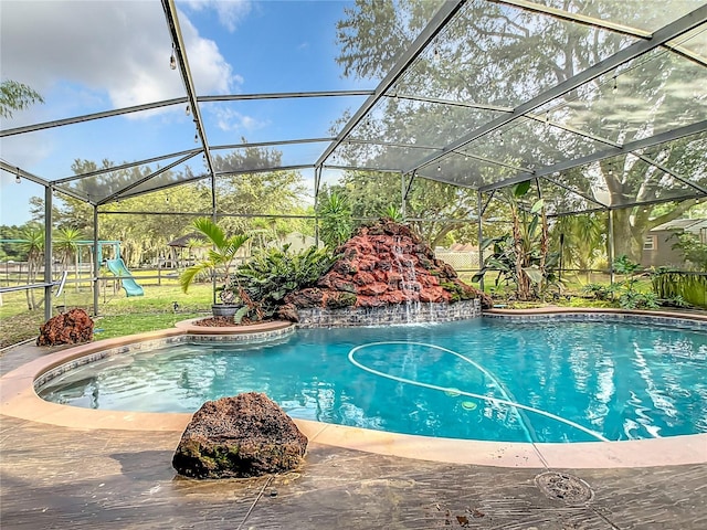 view of pool featuring a lanai, pool water feature, and a playground