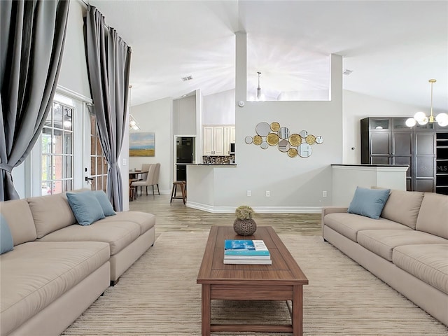 living room featuring light hardwood / wood-style flooring, high vaulted ceiling, and a notable chandelier