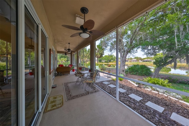 view of patio with ceiling fan and a water view