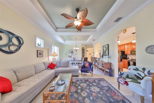 tiled living room featuring ceiling fan with notable chandelier, a tray ceiling, and crown molding