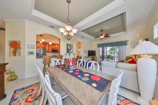 dining area with a tray ceiling, light tile flooring, and crown molding