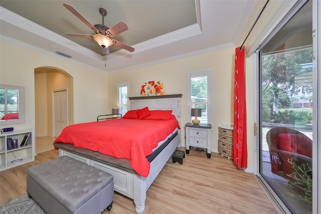 bedroom with light hardwood / wood-style floors, access to exterior, ceiling fan, a raised ceiling, and ornamental molding