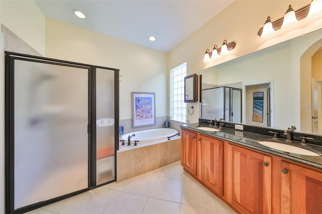 bathroom with tile floors, large vanity, plus walk in shower, and dual sinks