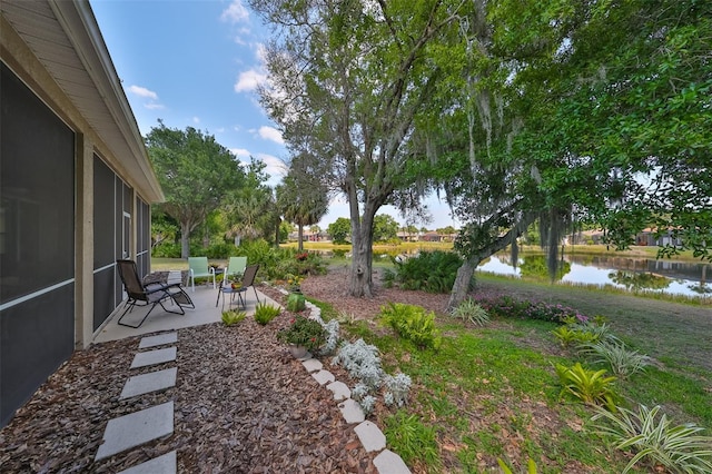 view of yard featuring a water view and a patio area