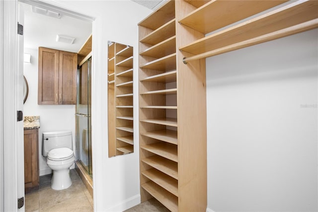 walk in closet featuring light tile floors