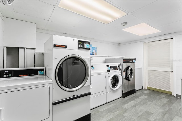 clothes washing area with light hardwood / wood-style flooring and washer and clothes dryer