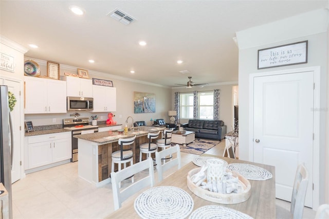 dining area with ceiling fan and ornamental molding