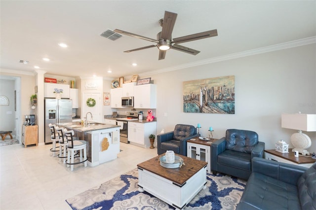 tiled living room with ceiling fan, crown molding, and sink