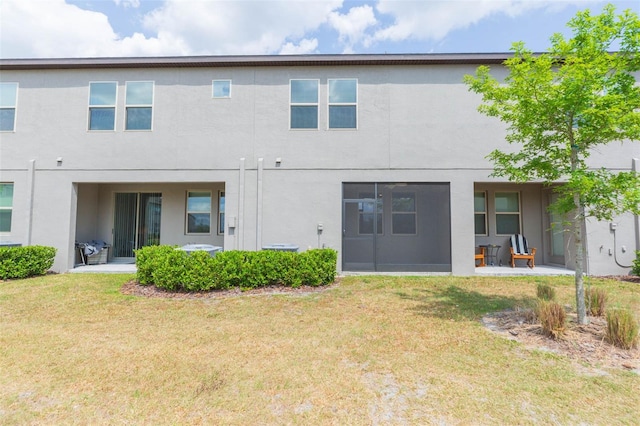 rear view of house featuring a yard and a patio