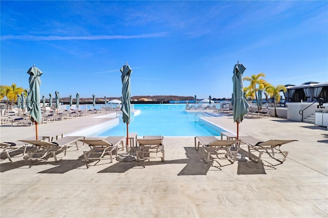 view of pool featuring a patio area and a water view