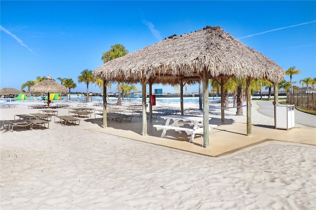 view of property's community featuring a view of the beach, a gazebo, and a water view