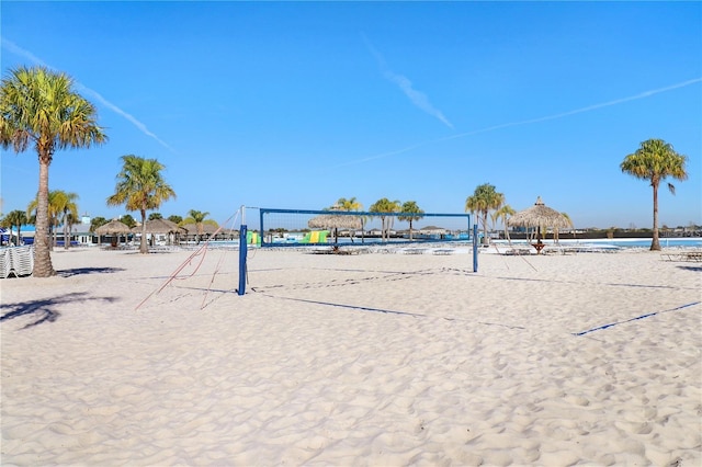 view of community featuring volleyball court, a water view, and a view of the beach